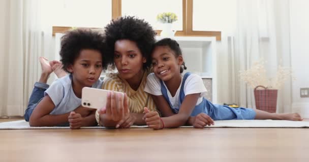 Moeder en kinderen hebben plezier met behulp van applicatie op mobiele telefoon — Stockvideo
