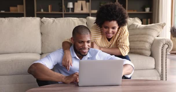 Африканская пара 30-х годов сидеть в гостиной использовать ноутбук — стоковое видео