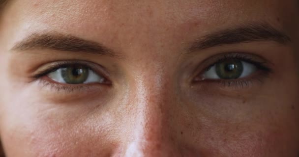 Красиві зелені очі молодої усміхненої жінки дивиться на камеру — стокове відео