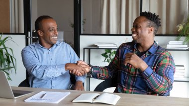 Mutlu Afrikalı Amerikalı müşteri ve çalışanlar el sıkışma toplantısını bitirdiler