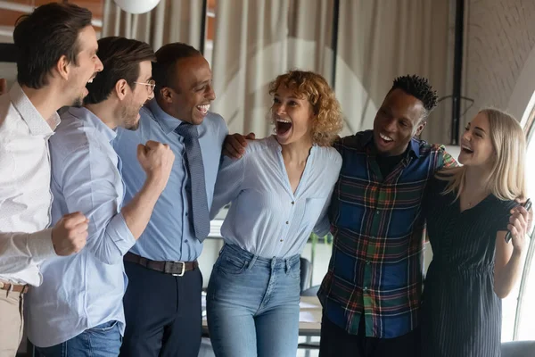Grupp glada glada glada olika anställda kramas, ropar av glädje — Stockfoto