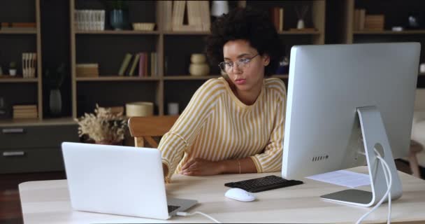 Jovem mulher de negócios preta compartilhar arquivos entre dispositivos PC desktop laptop — Vídeo de Stock