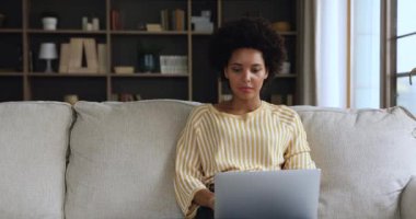 Genç siyahi kadın alışverişçi dizüstü bilgisayar kullanarak internetten mal alıyor.