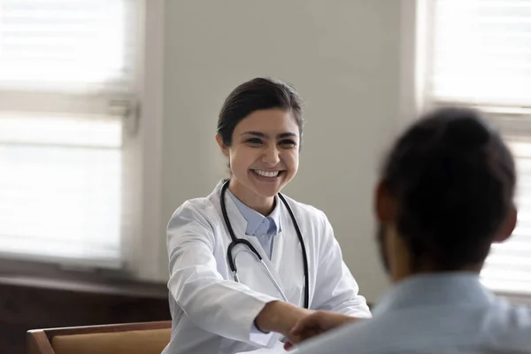 Feliz éxito joven médico indio dando apretón de manos a paciente —  Fotos de Stock