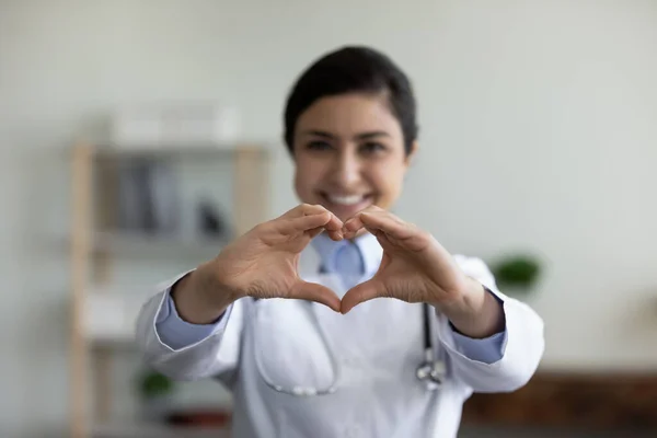 Happy Indian GP doctor showing finger heart shape at camera — Stock Photo, Image