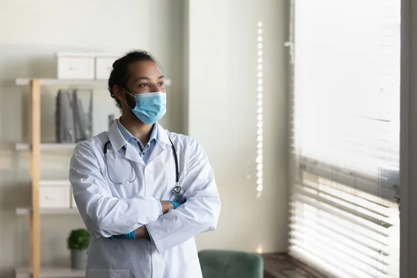 Serious male doctor in face mask, white coat with stethoscope — Stock Photo, Image
