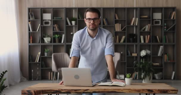 Selbstbewusster junger Geschäftsmann posiert in modernem Büro. — Stockvideo