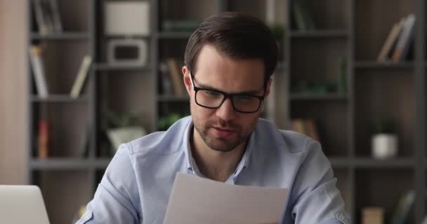 Jovem empresário interessado lendo papel com boas notícias. — Vídeo de Stock