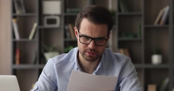 Joven empresario interesado leyendo el periódico con buenas noticias. — Vídeos de Stock