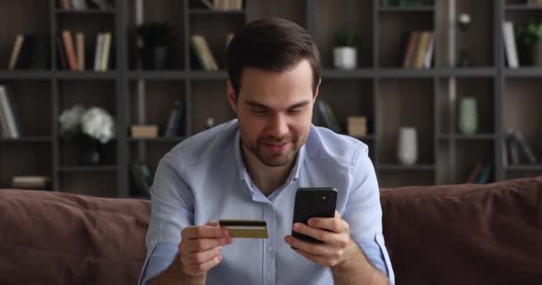 Felice giovane uomo che effettua pagamenti online su internet. — Video Stock