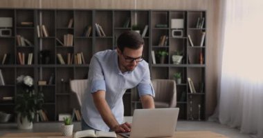 Düşünceli genç işadamı masada duran bilgisayarla çalışıyor..