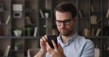 Akıllı telefon uygulamaları kullanarak konsantre olmuş mutlu milenyum işadamı.