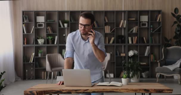 Jovem empresário feliz em óculos multitarefa no escritório moderno. — Vídeo de Stock