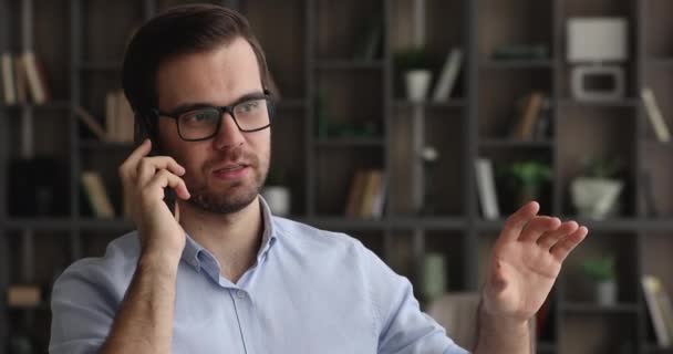 Sonriente joven hombre de negocios de 30 años manteniendo conversación telefónica. — Vídeos de Stock