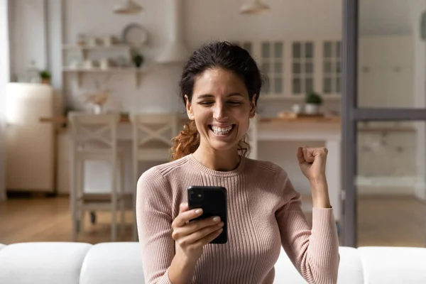 Eccitato trionfo giovane donna con buone notizie su smartphone — Foto Stock