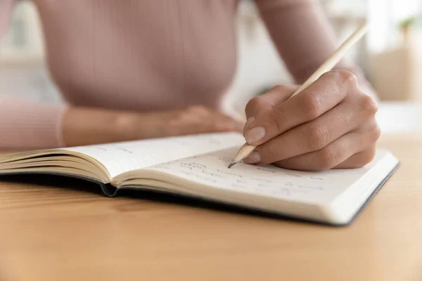 Gros plan de l'écriture de la femme dans le cahier — Photo