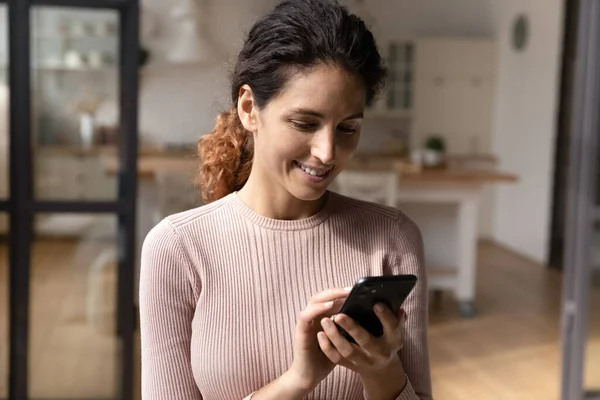 Leende kvinna använder smartphone sms online på gadget — Stockfoto