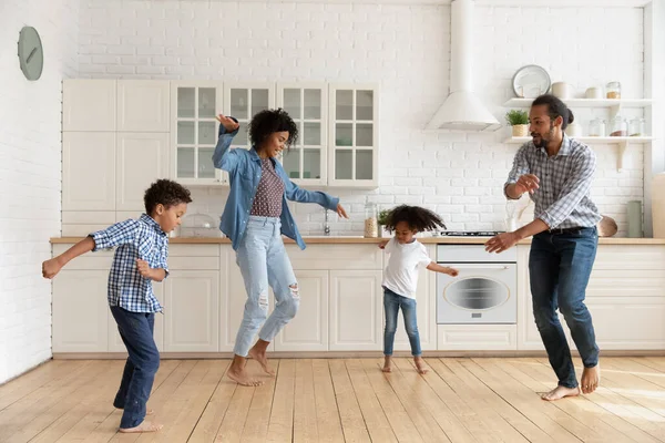 Heureuse famille afro-américaine avec des enfants dansant dans la cuisine ensemble — Photo