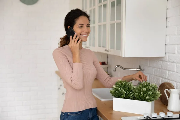 Modern mutfakta gülümseyen kadınlar cep telefonuyla konuşur. — Stok fotoğraf