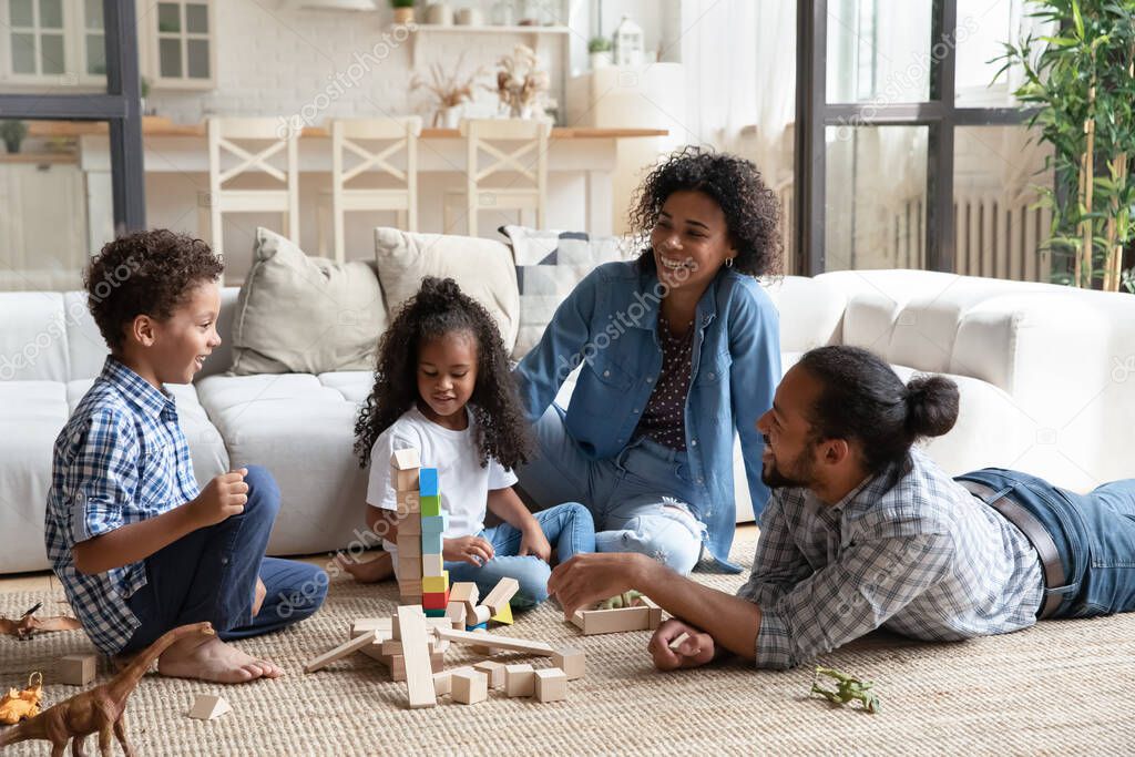 Happy African American parents and kids playing with toys together