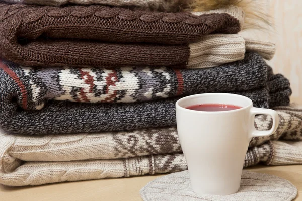 Pile of winter clothes and a cap of mulled wine — Stock Photo, Image