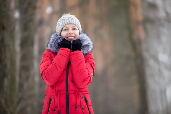 Kvinnliga porträtt utomhus i röd vinterjacka, ser ut i kameran — Stockfoto