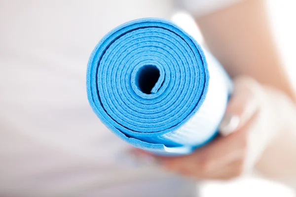 Zblízka: skládané modrý pilates mat v rukou ženy — Stock fotografie