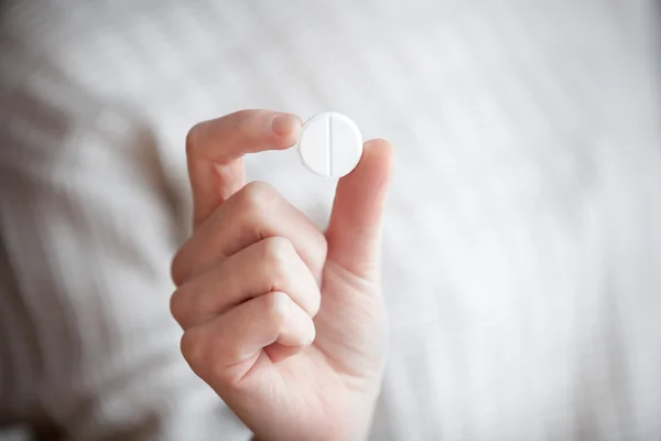 Pillola rotonda bianca nella mano delle donne — Foto Stock
