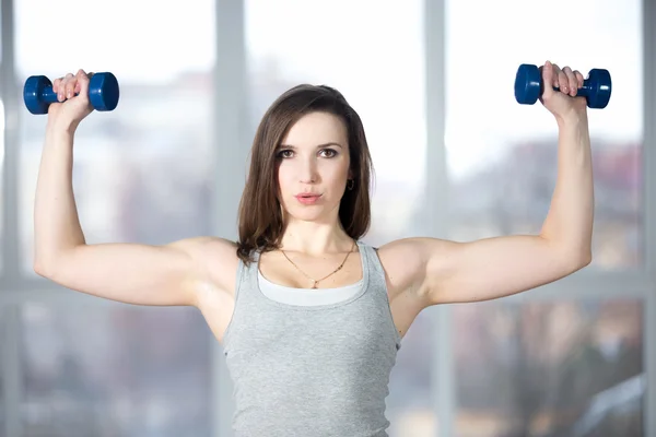 Sporty young woman lifting dumbbells — Stock Photo, Image