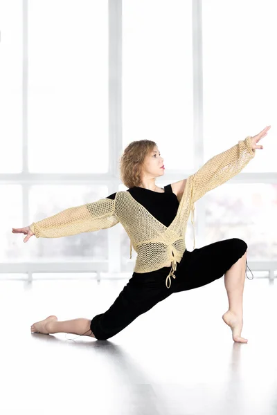 Deportiva hembra bailando, balanceándose en pose de embestida en clase —  Fotos de Stock