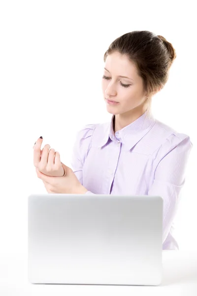 Young woman rubbing her hand after working on laptop — Stock Photo, Image