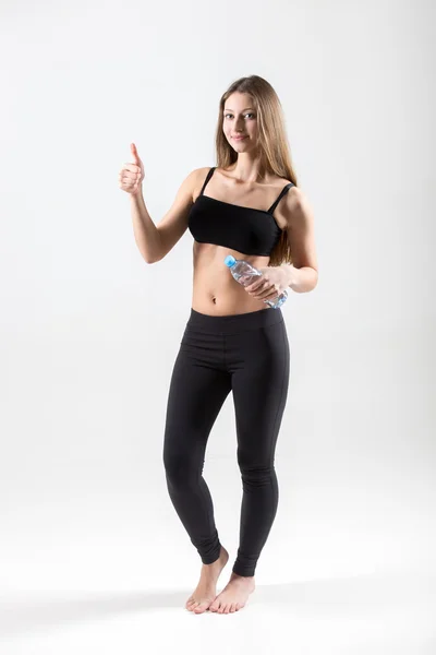 Athletic teenage girl with bottle of water showing gesture of ap — Stock Photo, Image