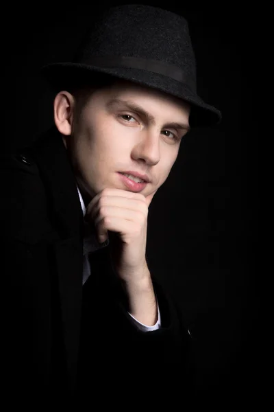 Portrait de jeune homme souriant en chapeau et manteau — Photo