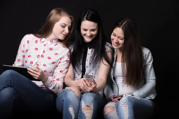 Vriendinnen kijken naar mobiele telefoons — Stockfoto