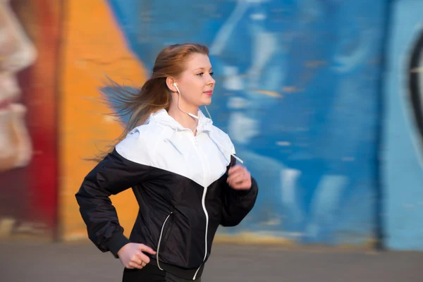 Läuferin beim Joggen neben Graffiti-Wand — Stockfoto