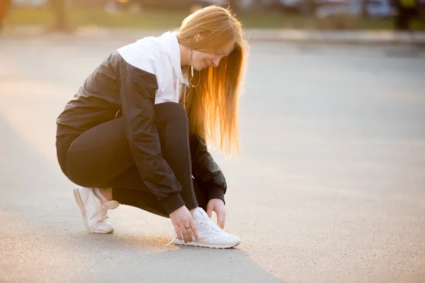 Deportiva chica fijación de cordones en zapatillas —  Fotos de Stock