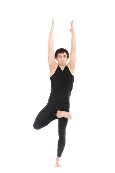 Sporty young man standing in Tree Pose — Stock Photo, Image