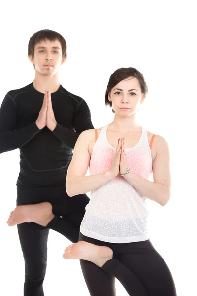 Dva lidé stojící v vrikshasana jóga pozice — Stock fotografie