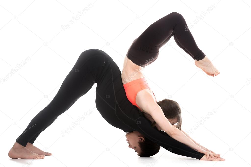 Yogi couple in yoga downward-facing dog and scorpion poses 