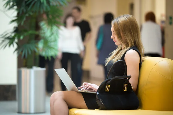 Ung kvinde arbejder på laptop - Stock-foto