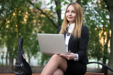 İle laptop bankta oturan kız