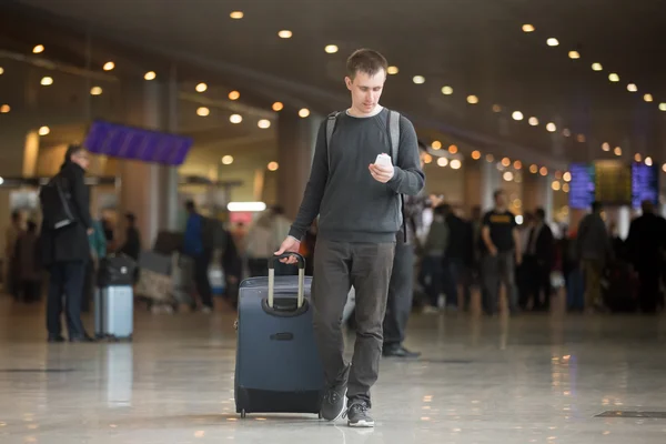 Viajero joven usando teléfono móvil en el aeropuerto —  Fotos de Stock