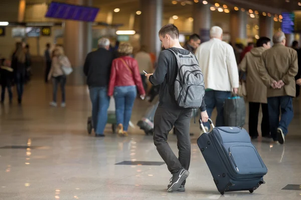 Junger Reisender mit Smartphone im Flughafen — Stockfoto