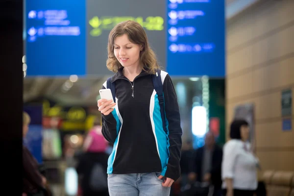 Girl using mobile phone in airport — Stock Photo, Image