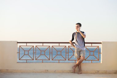 Genç adam telefonda konuşuyor.