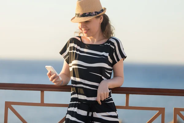 Mladá žena pomocí telefonu na moři ulice — Stock fotografie