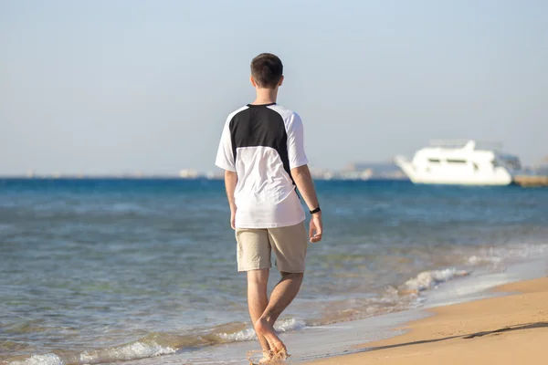 Jovem caminhando na costa — Fotografia de Stock