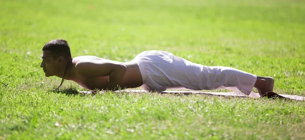 Chaturanga dandasana yoga pose in park — Stock fotografie