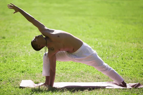 Yoga pose uthitta parshvakonasana no parque — Fotografia de Stock