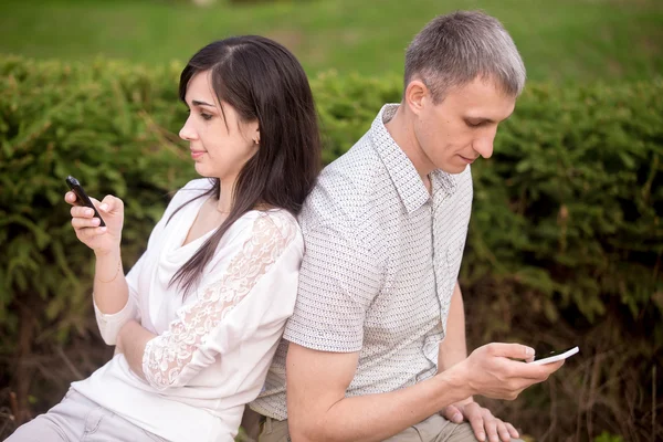 Couple absorbed in phone communication — Stock Photo, Image